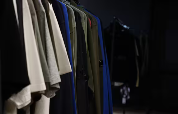 Close-up of curated clothing pieces on rack in showroom