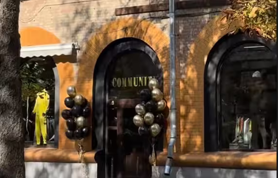 COMMUNITY clothing store entrance with arched windows and balloons