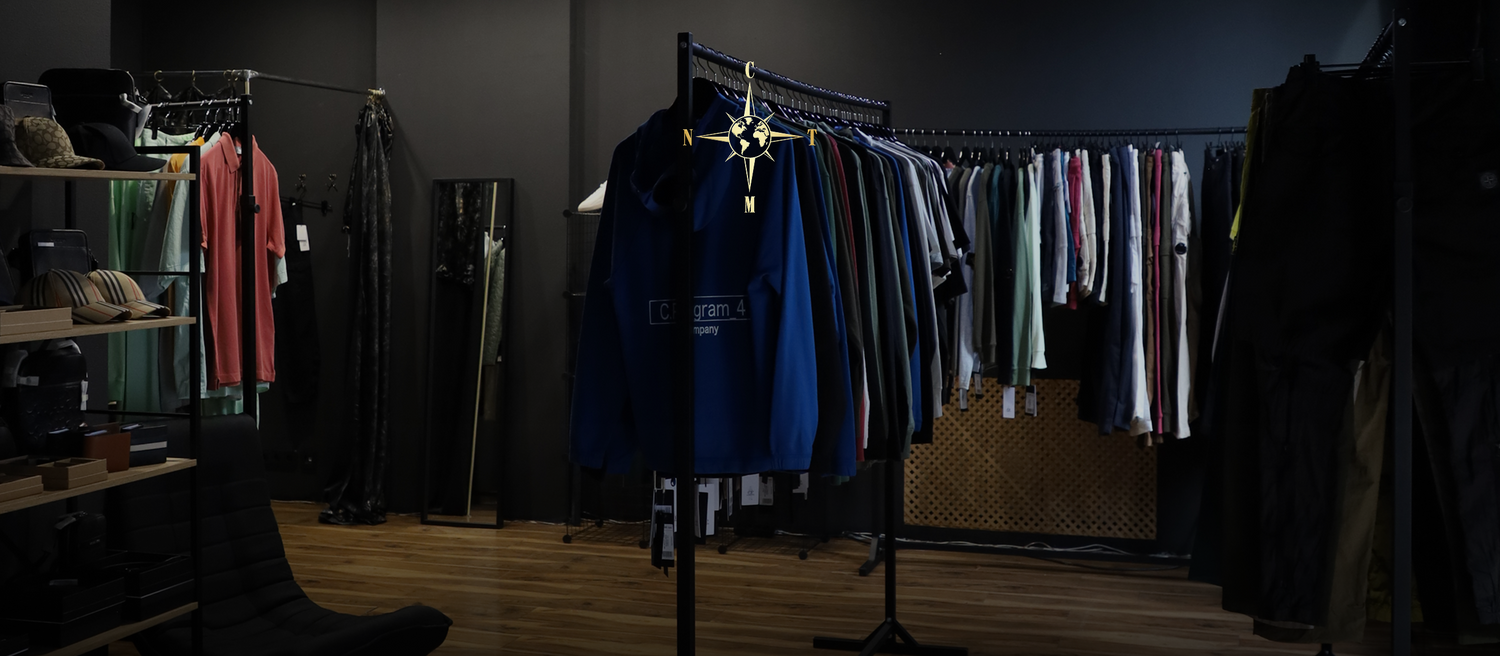 Dark premium fashion store interior with curated clothing display