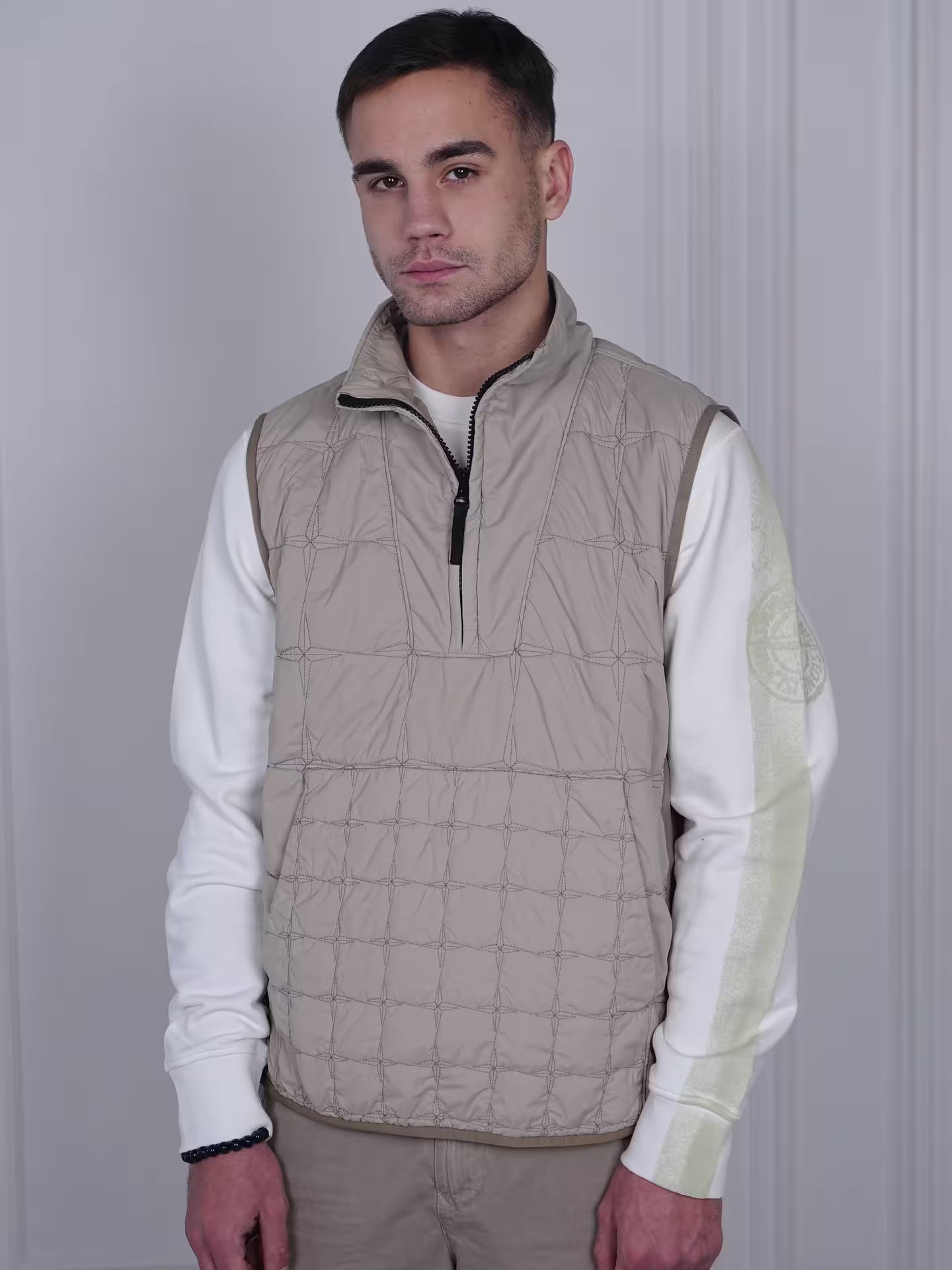 Man wearing beige quilted vest in minimalist streetwear style