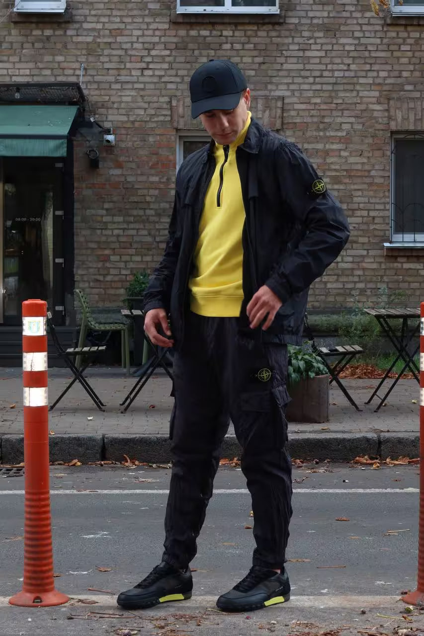 Man wearing black Stone Island urban outfit on city street