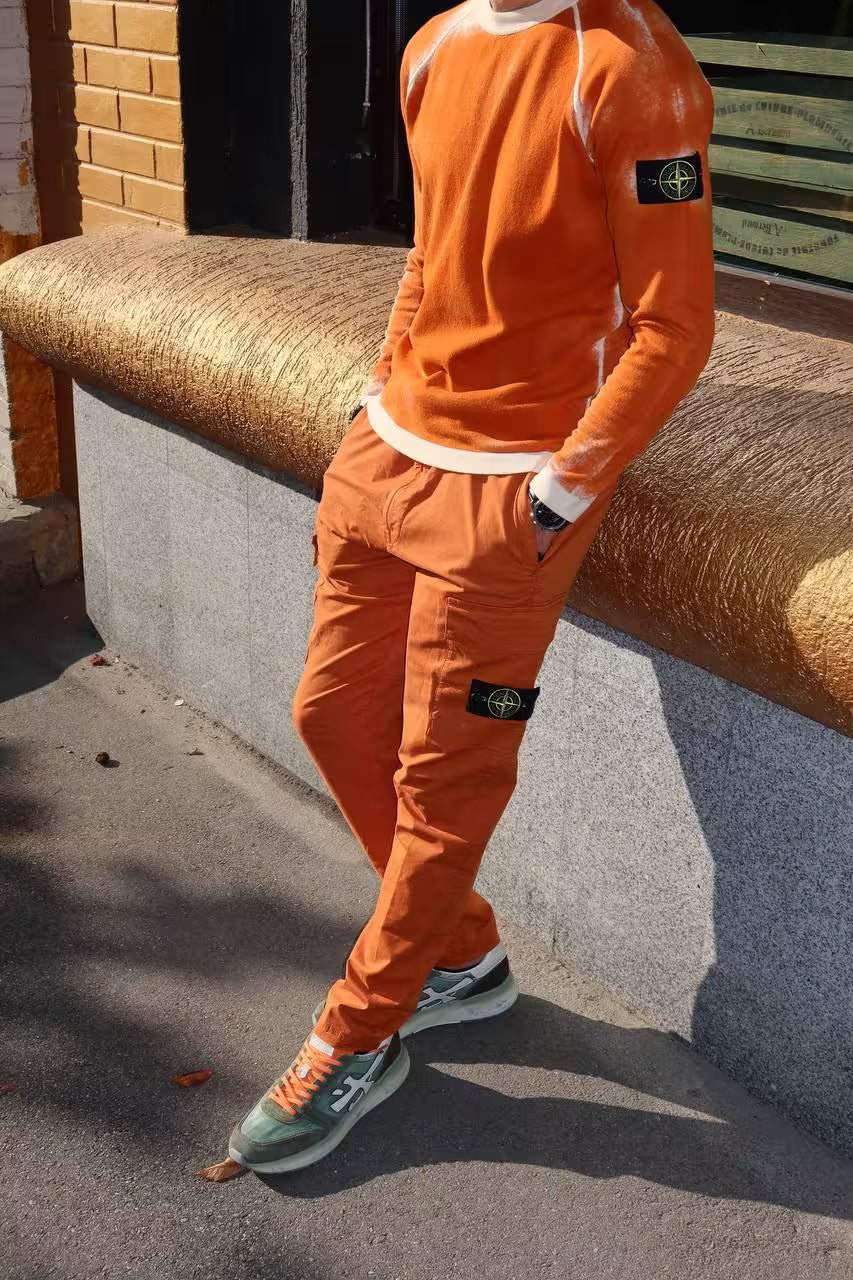 Man wearing orange Stone Island casual outfit near building