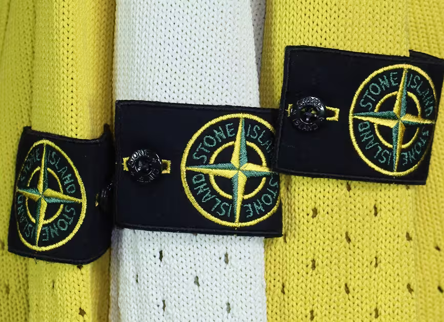 Close-up of Stone Island logo badges on knitwear